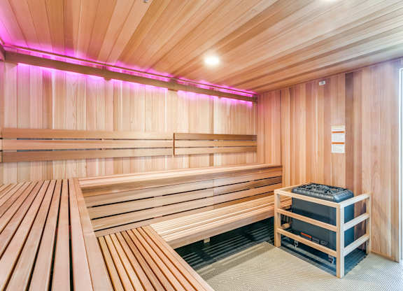 A sauna room with wooden benches and a heater.