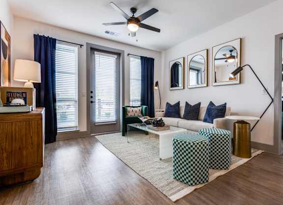 A living room with a sofa, a coffee table, and a ceiling fan.