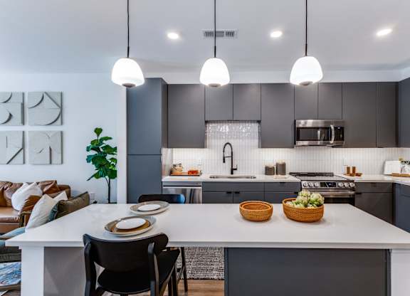 A modern kitchen with a dining table set for two.