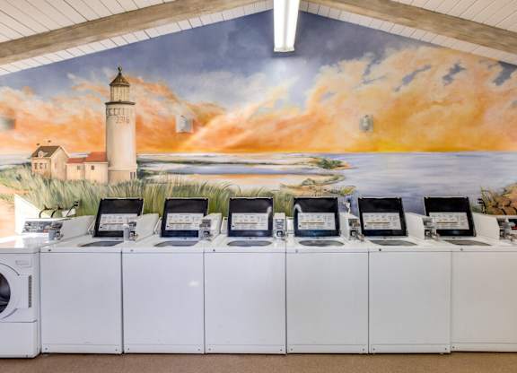 A row of computers are lined up in front of a mural.