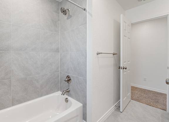 a bathroom with a tub and a shower and a door