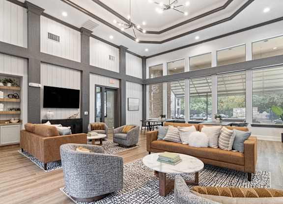 a living room with couches and chairs and a tv