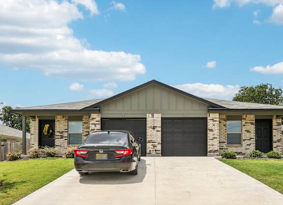 A car is parked in front of a garage.