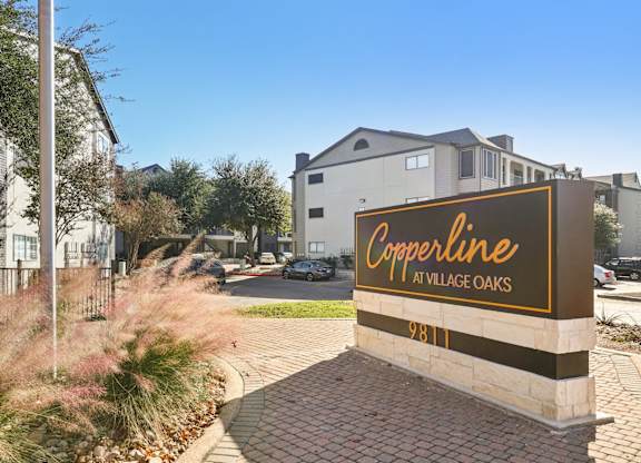 A sign for Copperline at Village Oaks stands in front of a building.