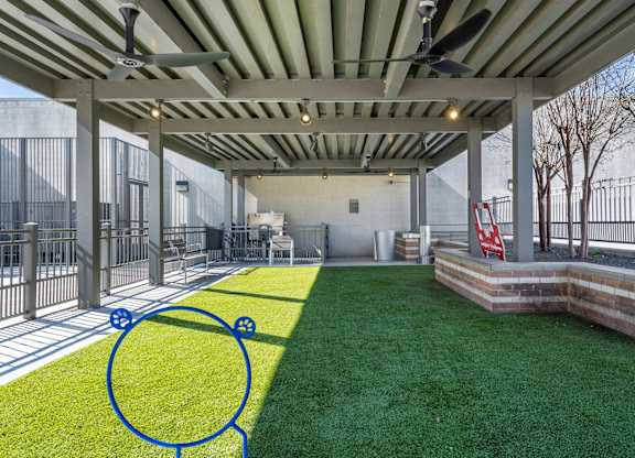 A patio with a green lawn and a blue circle drawn on it.