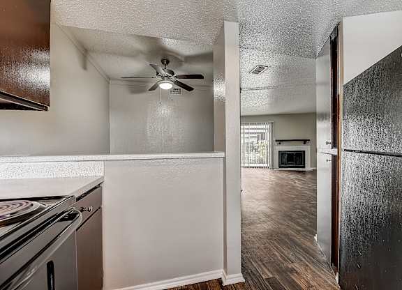 a kitchen and living room with a ceiling fan