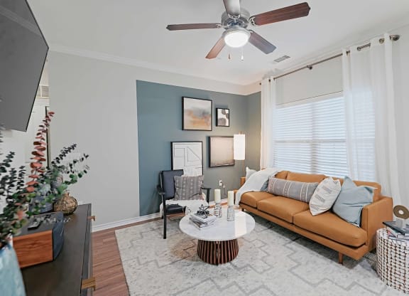 a living room with a couch and a ceiling fan