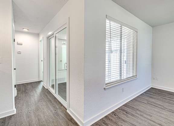 A room with a window and a sliding glass door.