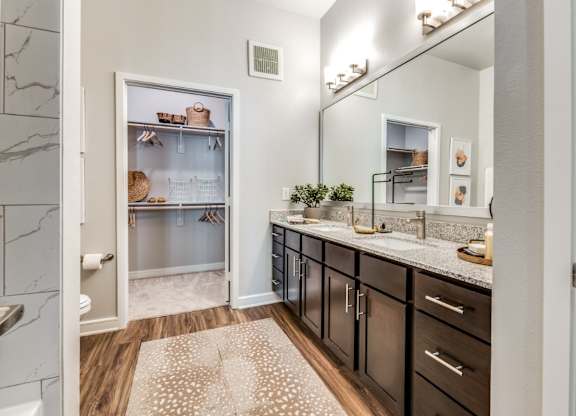 A kitchen with a refrigerator, countertops, and a rug on the floor.