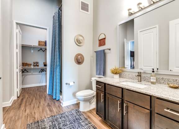 A bathroom with a toilet, sink, and a mirror.