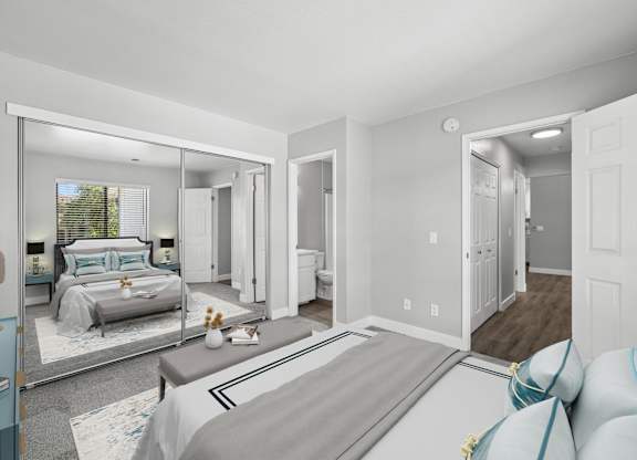 A bedroom with a large bed and a mirrored wall.