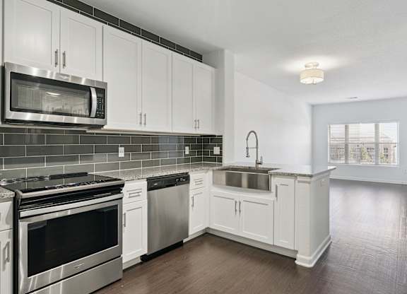 A kitchen with white cabinets and stainless steel appliances.