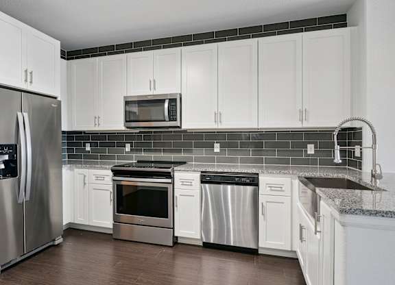 A kitchen with white cabinets and stainless steel appliances.