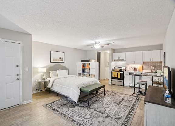 A bedroom with a bed, nightstand, and a rug.