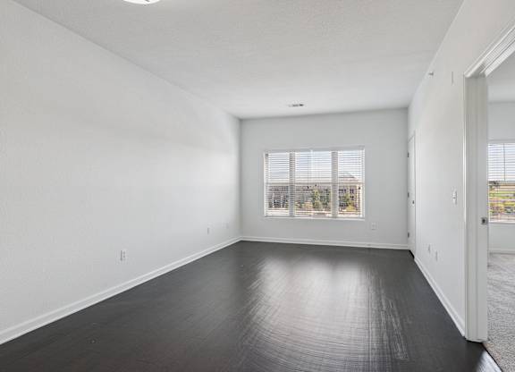A large empty room with a window and a door.