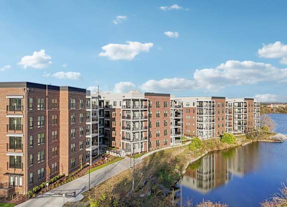 A row of modern apartment buildings are situated next to a body of water.