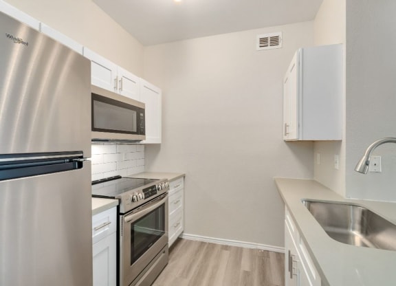 a kitchen with stainless steel appliances and white cabinets