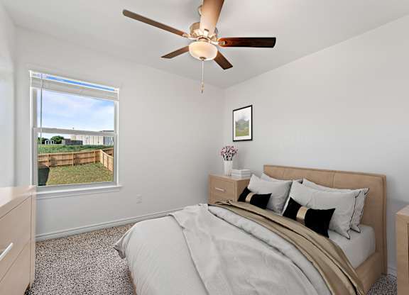 A bedroom with a large bed and a ceiling fan.