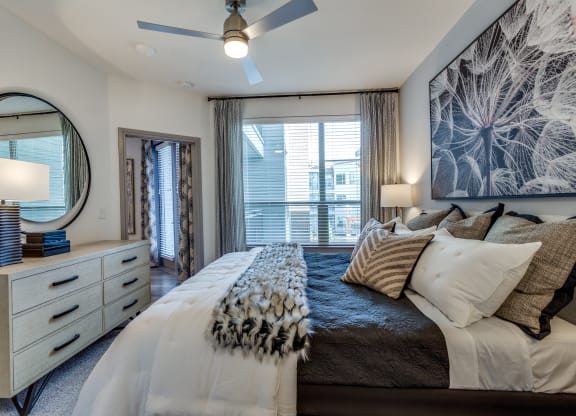 a bedroom with a large bed and a ceiling fan