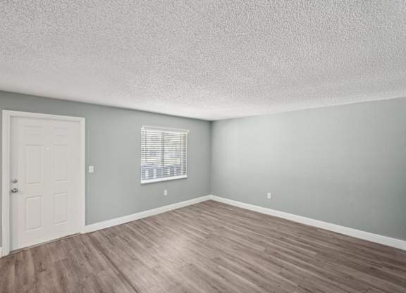 A room with a white door and a window with blinds.