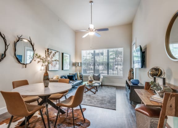 an open living room and dining room with a large window and a table and chairs
