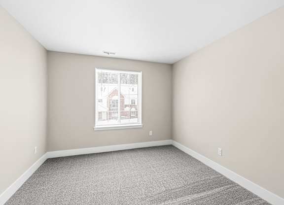 an empty room with white walls and a window