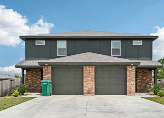 A house with a grey roof and a garage door.