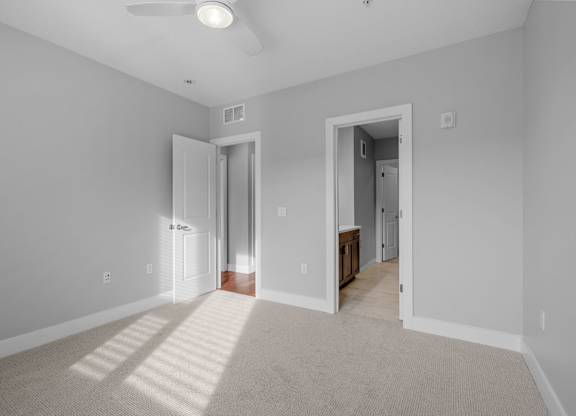 a spacious living room with gray walls and a carpeted floor