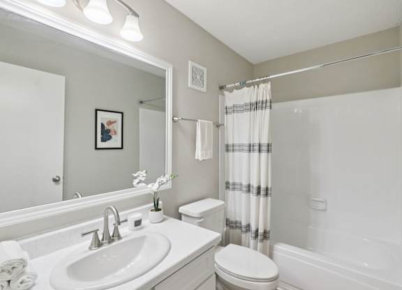 A bathroom with a white sink, toilet, and bathtub.
