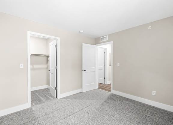 an empty room with three doors and a carpeted floor