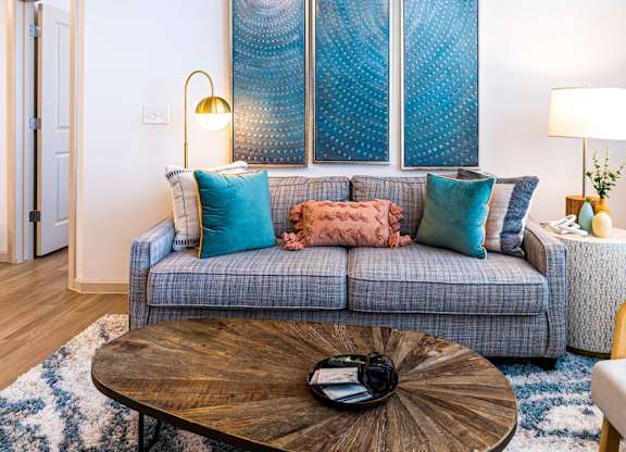 A living room with a grey couch and a wooden coffee table.