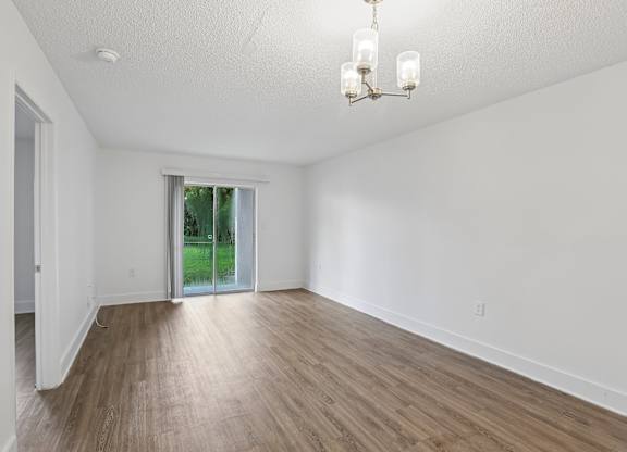 A room with wooden floors and a chandelier.