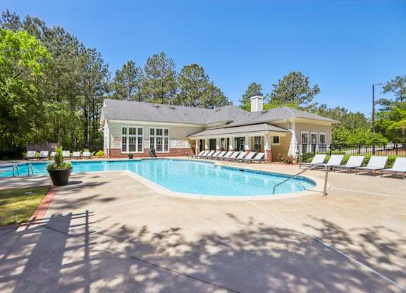 A house with a pool in front of it.