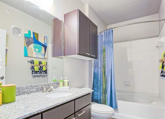 A bathroom with a white sink and a blue shower curtain.