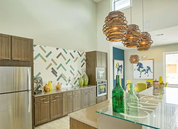 A modern kitchen with a glass counter top and wooden cabinets.
