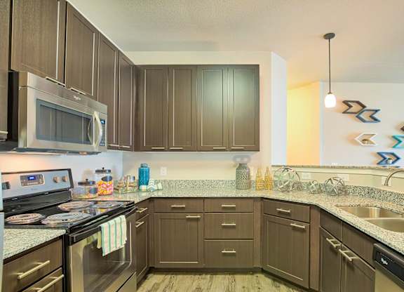 A kitchen with brown cabinets and a stainless steel refrigerator.