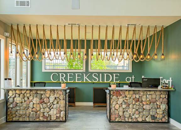 A reception area with a green wall and a sign that says CREEKSIDE at the top.