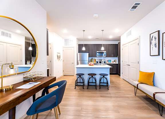 A modern kitchen with a blue chair and a wooden table.