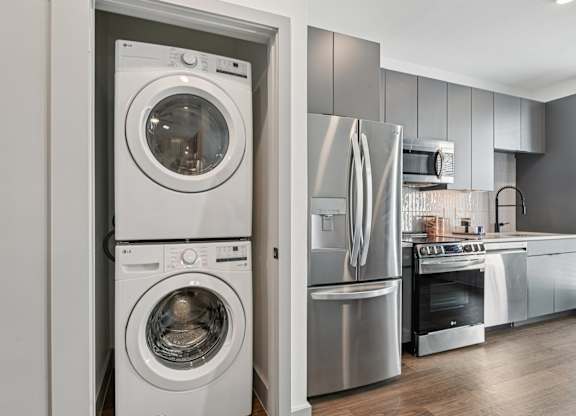 A modern kitchen with a washing machine and refrigerator.