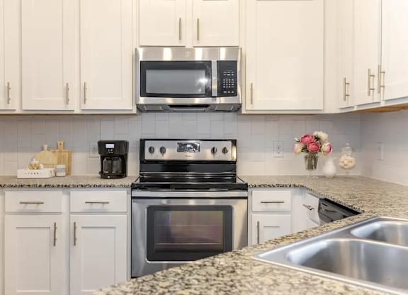 A kitchen with a stove, oven, microwave, and refrigerator.