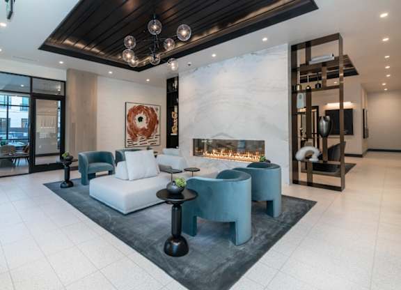 A modern living room with a fireplace and a large painting on the wall.