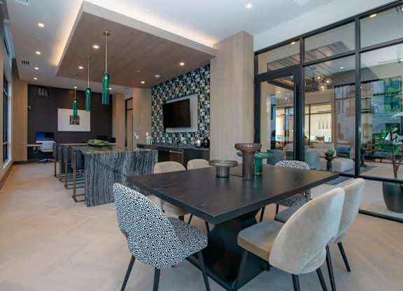 A modern dining room with a large table and chairs.