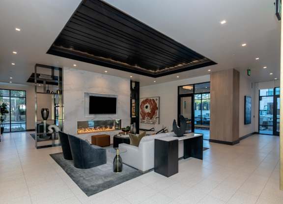 A modern living room with a fireplace and a black ceiling.
