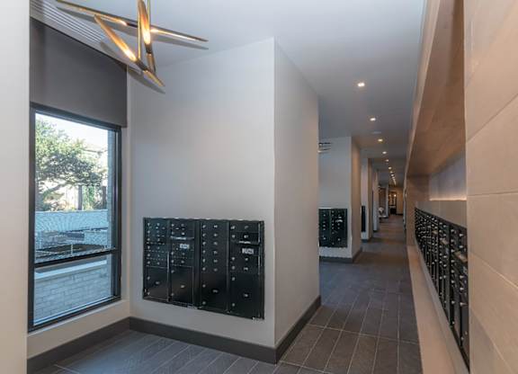 A long hallway with a black mailbox on the wall.