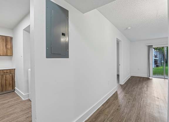 A room with a white wall and a wooden floor.