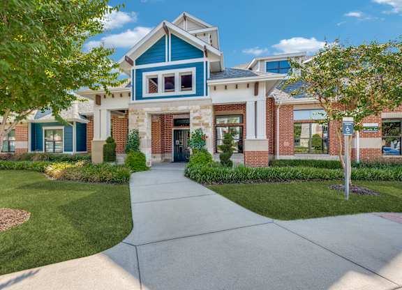 A blue and white house with a green lawn in front.