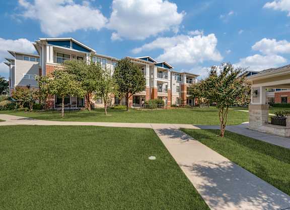 A modern building with a green lawn in front.