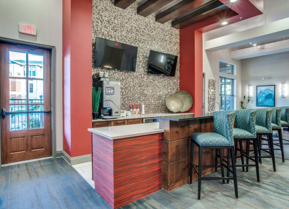 a lobby with a bar and chairs and a television