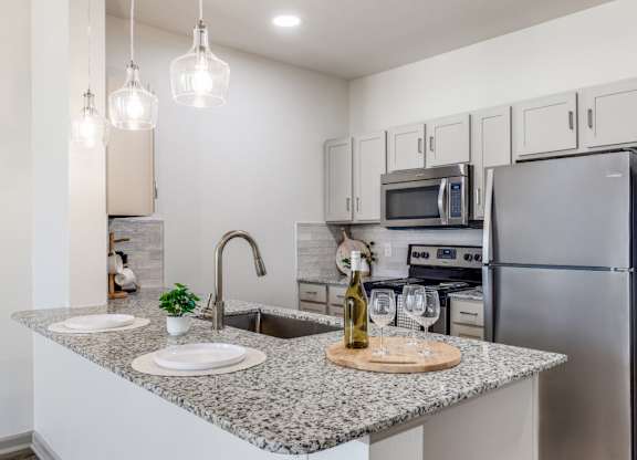 A kitchen with granite countertops and stainless steel appliances.