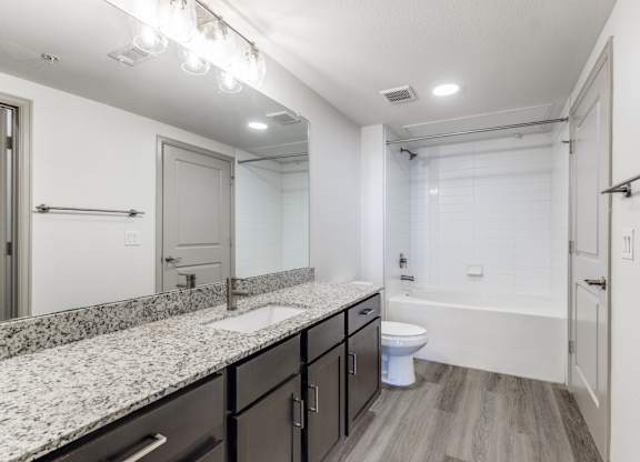 A bathroom with a toilet, sink, and bathtub.